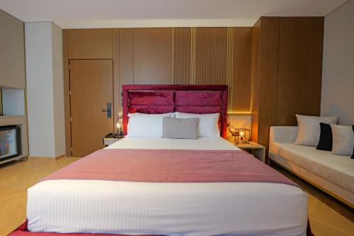 a bedroom with a large bed with a purple headboard at Duka's Hotel in Ksamil