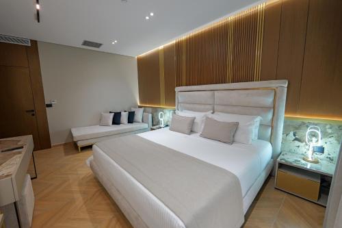 a bedroom with a large white bed and a couch at Duka's Hotel in Ksamil