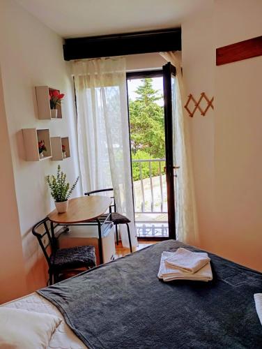 a bedroom with a bed and a table and a window at Rooms Helena in Krk