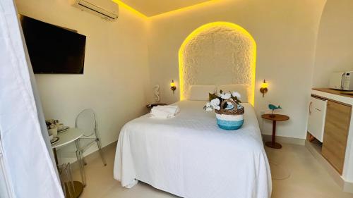a bedroom with a white bed with a basket of flowers at D'Blue Búzios Hotel Boutique in Búzios