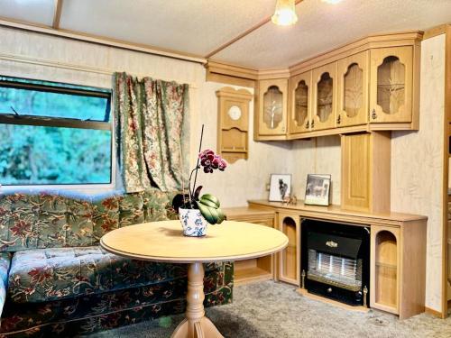 een woonkamer met een bank en een tafel met bloemen bij Holenderek Agro-Stajnia in Rudniki