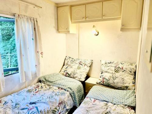 een kleine kamer met twee bedden en een raam bij Holenderek Agro-Stajnia in Rudniki