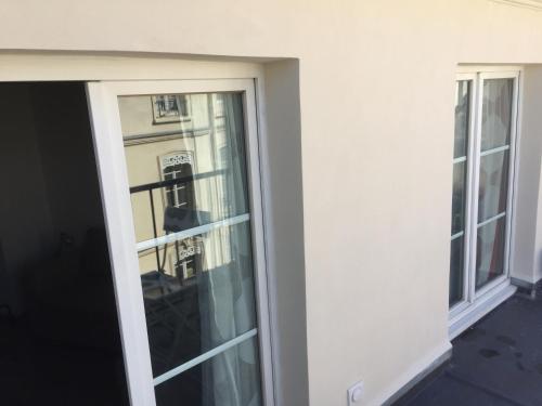 une porte coulissante en verre reflétant un bâtiment dans l'établissement Studio K with terrace, à Paris