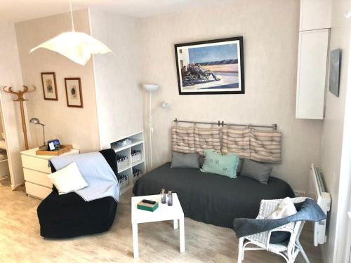 un salon avec un lit et une table dans l'établissement Appartement cosy à Trouville, à Trouville-sur-Mer