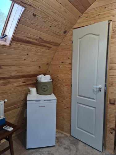 a room with a white door and a refrigerator at Căsuțe în mijlocul naturii - Wild Camp Avrig in Avrig
