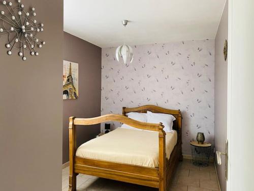 - une chambre avec un lit en bois et un couvre-lit blanc dans l'établissement Maison au calme avec terrasse, à Saint-Julien-en-Saint-Alban