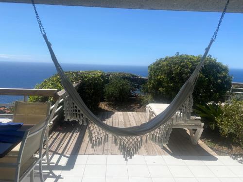 a hammock on a deck with the ocean in the background at Sunny Home Costa Plana-Monaco -Cap D'Ail in Cap d'Ail