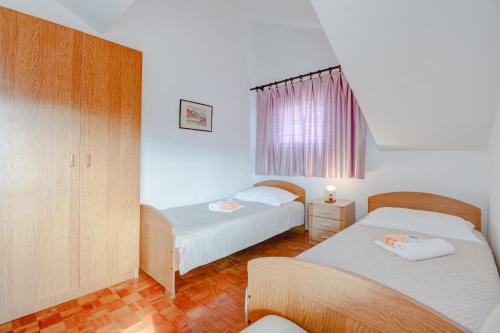 a bedroom with two beds and a window at Apartment with beautiful view and big terrace in Vrboska