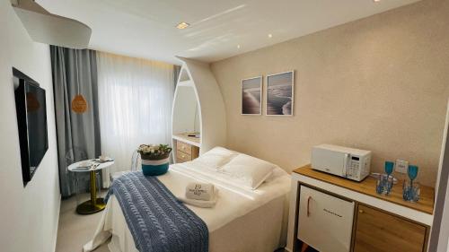 a small room with a bed and a mirror at D'Blue Búzios Hotel Boutique in Búzios