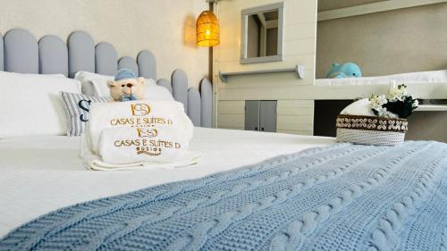 a bed with a pillow with a dog on it at D'Blue Búzios Hotel Boutique in Búzios