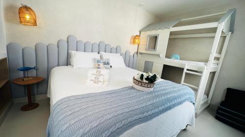 a bedroom with a blue and white bed and a bunk bed at D'Blue Búzios Hotel Boutique in Búzios
