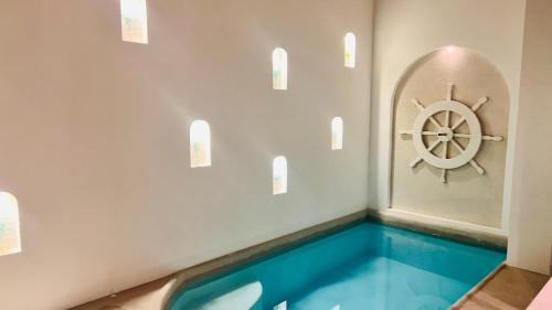 a swimming pool with a ship wheel on the wall at D'Blue Búzios Hotel Boutique in Búzios