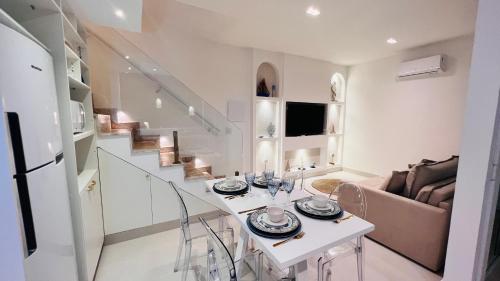 a white living room with a table and a couch at D'Blue Búzios Hotel Boutique in Búzios