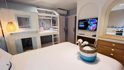 a bedroom with a bed with a crib and a tv at D'Blue Búzios Hotel Boutique in Búzios