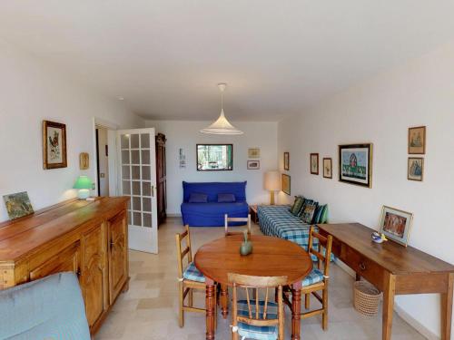 un salon avec un canapé bleu et une table dans l'établissement Appartement Calme avec Terrasse et Parking à 5 min de la Mer à Menton - FR-1-196-203, à Menton
