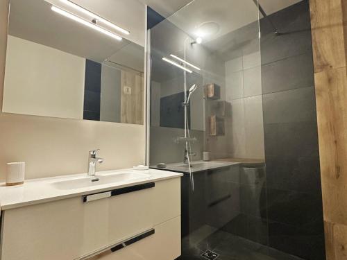 une salle de bain avec un lavabo et une douche dans l'établissement Appartement cosy avec terrasse, proche commerces, ski-bus, et équipements confort (WiFi, TV, garage) - FR-1-624-47, à Samoëns