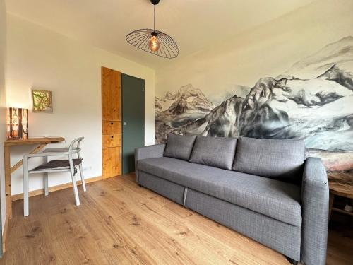 un salon avec un canapé et un tableau au mur dans l'établissement Appartement cosy avec terrasse, proche commerces, ski-bus, et équipements confort (WiFi, TV, garage) - FR-1-624-47, à Samoëns