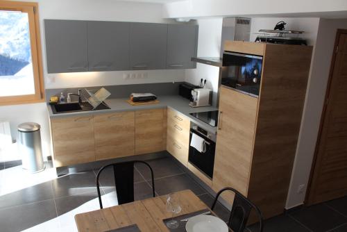 - une cuisine avec un comptoir, une table et une cuisinière dans l'établissement Appartement au pied des pistes dans nouvelle résidence, à Oz