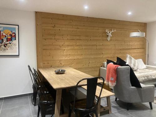 une salle à manger avec une table et un canapé dans l'établissement Appartement au pied des pistes dans nouvelle résidence, à Oz