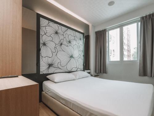 a bedroom with a bed with a flower mural on the wall at Hi Hotel Dot in Singapore