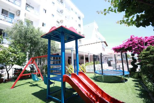 um parque infantil com um escorrega e um baloiço em Hotel Lakaj em Velipoja