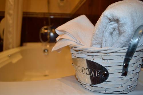 a basket of towels on a counter next to a bath tub at Hotel Shterev Karlovo in Karlovo