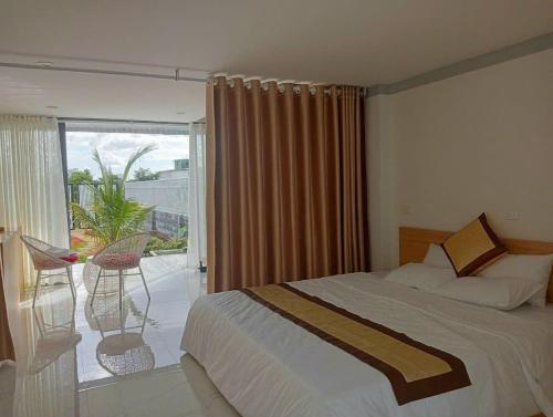 une chambre avec un lit et un balcon avec vue dans l'établissement Homestay Gia Đình, à Buôn Kao