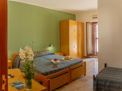una camera da letto con un letto e un tavolo con dei fiori sopra di La Rotonda a Mattinata