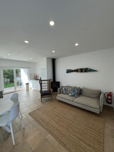 a living room with a couch and a table at TALAFA Beach House - Almograve in Almograve