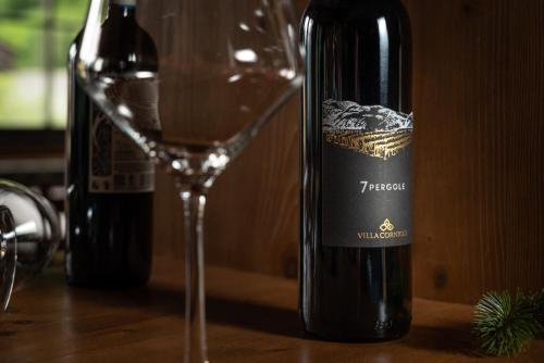 a bottle of wine sitting next to a wine glass at Hotel Betulla in Madonna di Campiglio