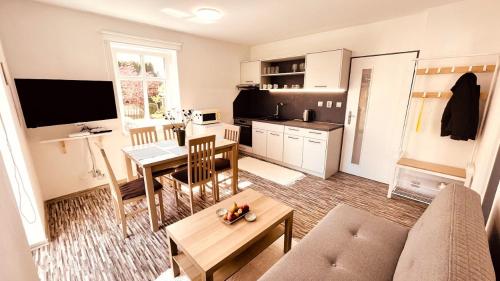 a living room with a couch and a table and a kitchen at Apartmány Hvězdecká in Broumov