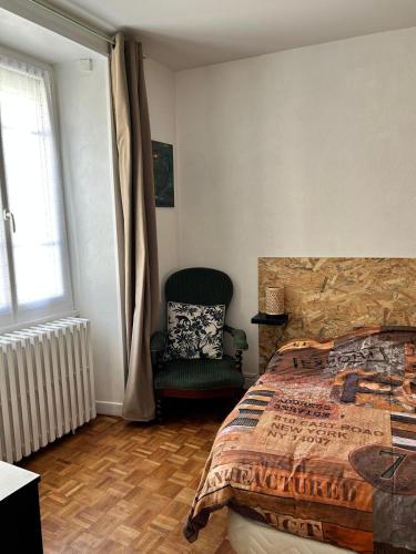 une chambre avec un lit, une chaise et une fenêtre dans l'établissement Les jardins de Felix, à Bourges