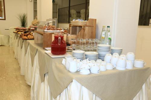 een lange tafel met witte kopjes en borden erop bij Hotel Diamante in Cattolica