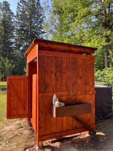 a wooden out house with a toilet in it at Treehouse U rybníka in Osečná