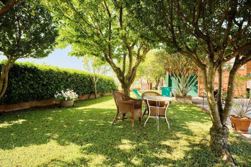 a table and chairs in a yard with trees at Art of living Villa Ciliegio in Vicobellignano