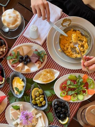 萨利杰尔梅Akvilla House Sarigerme的一张桌子上摆放着几盘食物，一个人正在准备食物。