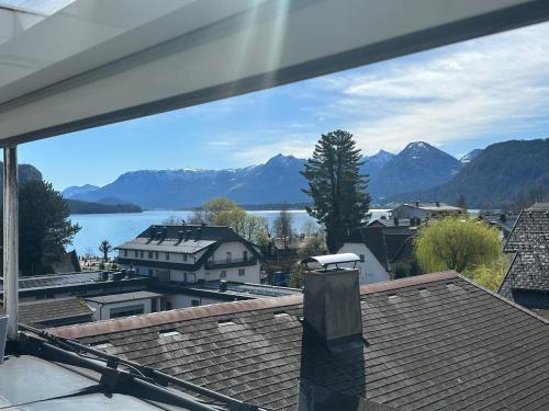 a view of a lake and mountains from a house at Nannerls Penthouse in Sankt Gilgen