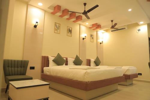 a bedroom with a large bed and a chair at KANS ONE - Hotel & Banquets in Chennai