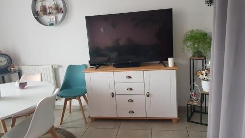 un salon avec une télévision sur une commode blanche dans l'établissement Vendee Globe 2024, à Les Sables-dʼOlonne