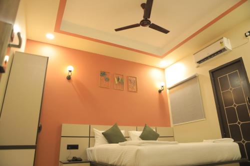 a bedroom with two beds and a ceiling fan at KANS ONE - Hotel & Banquets in Chennai