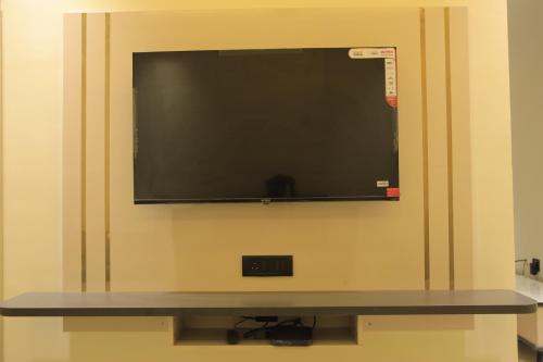 a flat screen tv hanging on a wall at KANS ONE - Hotel & Banquets in Chennai