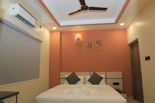 a bedroom with a bed and a ceiling fan at KANS ONE - Hotel & Banquets in Chennai