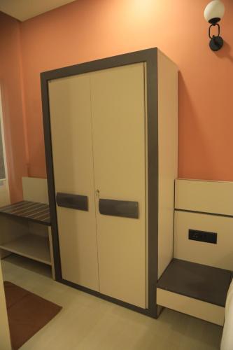 a closet with a door in the corner of a room at KANS ONE - Hotel & Banquets in Chennai