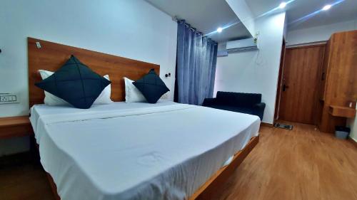 a bedroom with a large white bed with blue pillows at The Plush - Best Seller - Budget Luxury Stays in Dehradun
