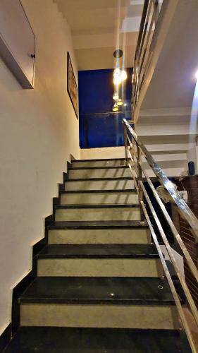 a set of stairs with a blue painting on the wall at The Plush - Best Seller - Budget Luxury Stays in Dehradun
