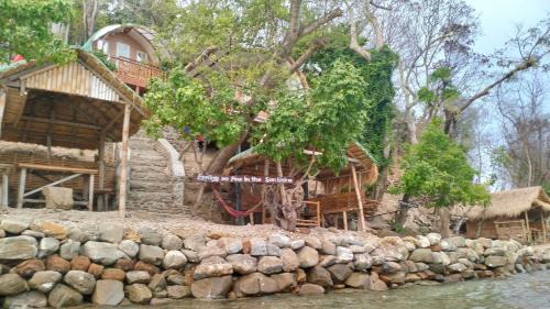 a house next to a river with a rock wall at MegaBuena Beach Resort in Mansalay
