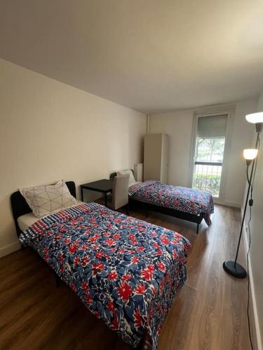- une chambre avec 2 lits et une lampe dans l'établissement Single bed in a 2 bed dormitory room near Paris, à Argenteuil