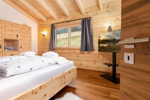 a bedroom with a bed in a wooden house at Herzbluad Chalet in Wallgau