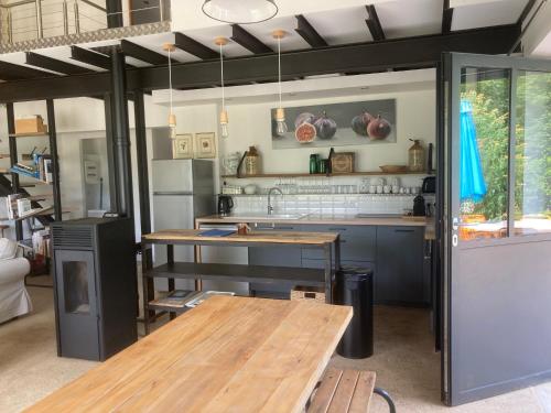una cucina con un tavolo di legno e un bancone di Workshop n°2 for 6 people with shared pool a Semur-en-Auxois