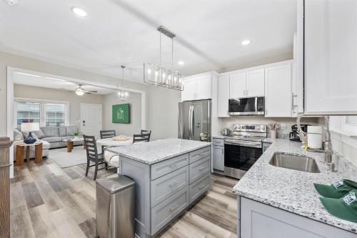 a kitchen with white cabinets and a living room at Pier View - Spacious Home Sleeps 8 - Pet Friendly in Myrtle Beach